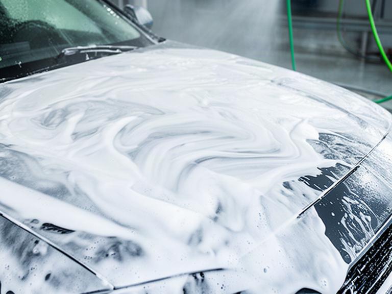 Getto d’acqua sul cofano di un’auto durante il lavaggio esterno
